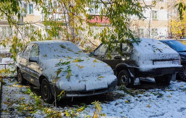Sonbaharın sonlarında şiddetli bir kar fırtınası sırasında park yerine park etmiş bir yolcu sedanı karla ve dallarla kaplıydı. Bulanık odak