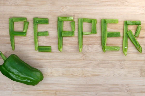 Pimenta Verde Madura Com Palavra Pimenta Pedaços Fundo Madeira — Fotografia de Stock