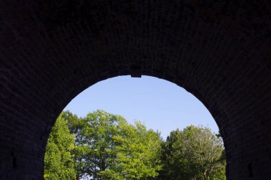 Eski kıvrımlı tünel girişi ağaçlara bakıyor 