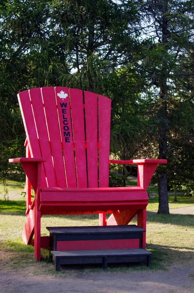 大红色Adirondack椅子在公园里 欢迎在它上面 — 图库照片
