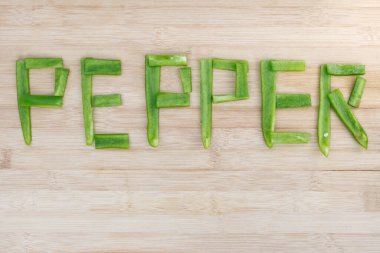 yeşil biberler ahşap zemin üzerinde kelime karabiberi yazarken kopya alanı