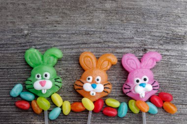 Kopya alanı olan ahşap bir arka planda üç şekerleme tavşanı.