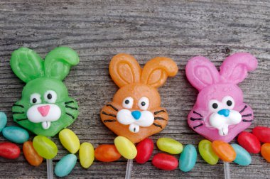 Kopya alanı olan ahşap bir arka planda üç şekerleme tavşanı.