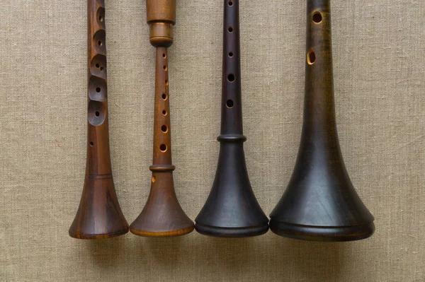 Dört farklı şekil, renk, boyut ve tonda halk müziği enstrümanları - bir zhaleika ve üç shawm (schalmeis) - gri keten resim tuvali üzerinde