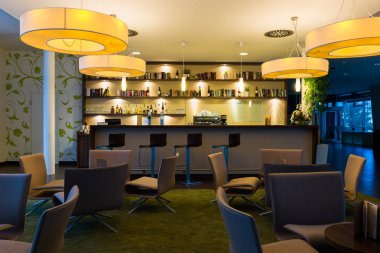 Nice hotel lounge bar with bottle shelfs and seats, tables, lights