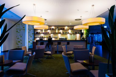 Yalnız kız, yalnız ışıklı otel barında oturur