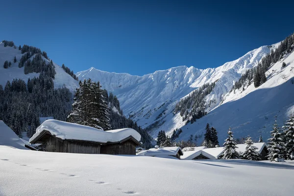 Chalets avec neige sur le toit dans les Alpes autrichiennes en hiver — Photo