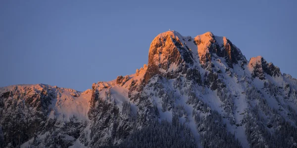 Red lighted peak of austrian mountain at sunset in winter — Stock Photo, Image