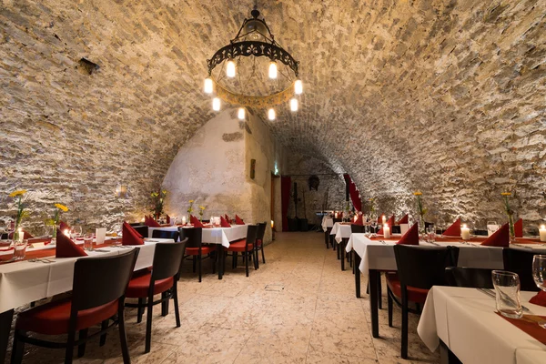 Романтический арочный камень в рыцарской комнате со столами и свечами — стоковое фото