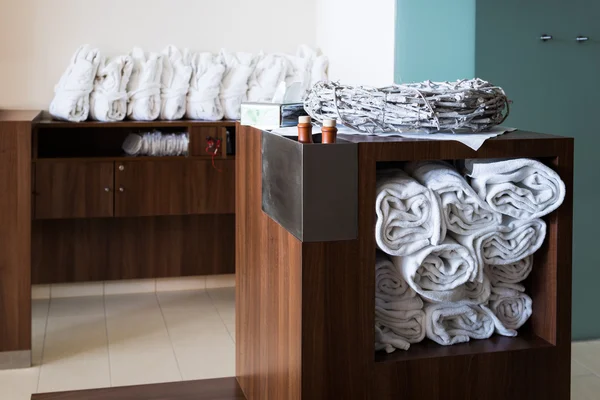 White towels and bathrobes sorted on wooden cupboards and shelfs — Stock Photo, Image