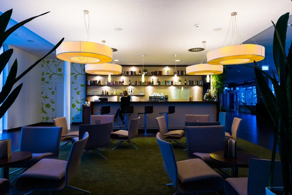 Eenzaam meisje zit alleen in moderne verlichte hotelbar — Stockfoto