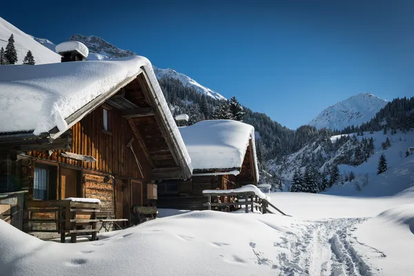 Houten huizen op Oostenrijkse bergen op winter met een heleboel sneeuw Stockfoto