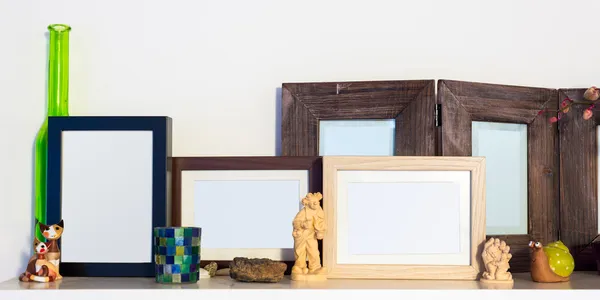 Several wooden pictures frames standing on shelf — Stock Photo, Image