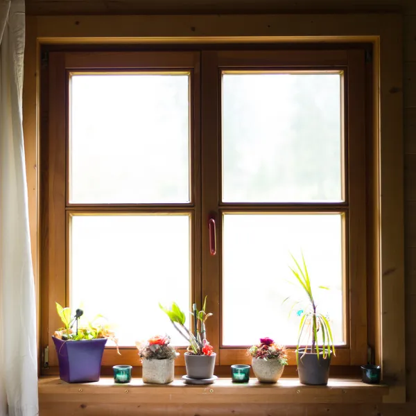 stock image Wooden window with flowers on ledge