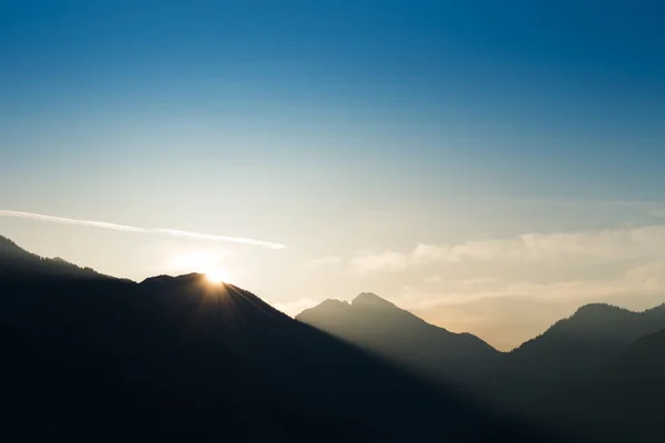Rayon lumineux sur le bord de la montagne au lever du soleil et ciel bleu — Photo