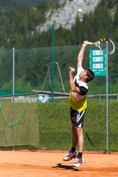 Tennis player serving on sand court — Stock Photo, Image