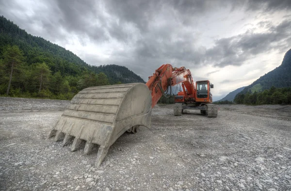 Perspective of digger power shovel in red on gravel — Stock Photo, Image