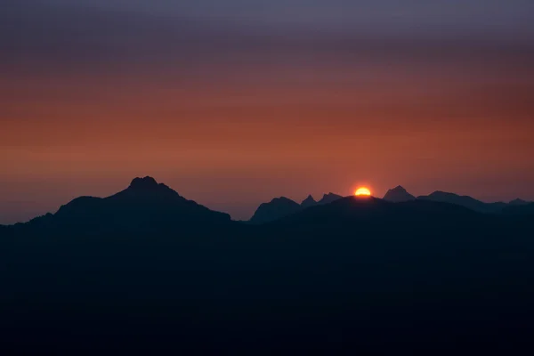 Sun rises over tyrol mountains with orange sky — Stock Photo, Image