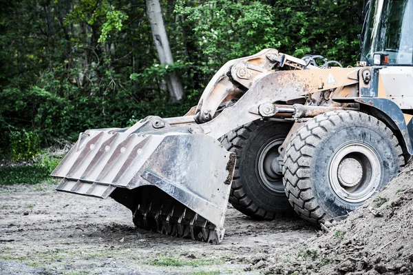 Wheel loader stands at building site in front of forest — Stock Photo, Image