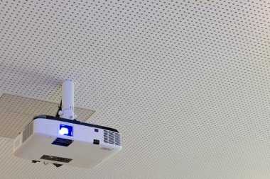 Turned on lcd video projector with ceiling suspension clipart