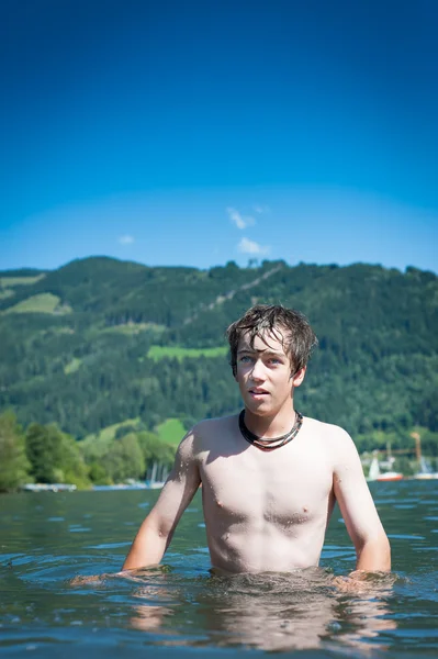 Tennager boy stands in lake zell am see — Stock Photo, Image