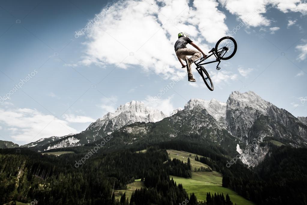 Biker rotates his bike arround high in the air