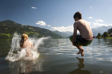 kız zaten sıçramasına su ve hava onlar çocuk nereye jumoing güzel doğa ve dağ arkada bir göle