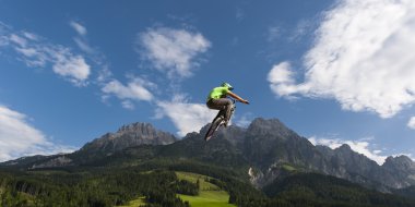 Genç freestyler güzel doğa, dağlar ve arka bulutlu gökyüzü hava içine onun bmx yüksek atlar