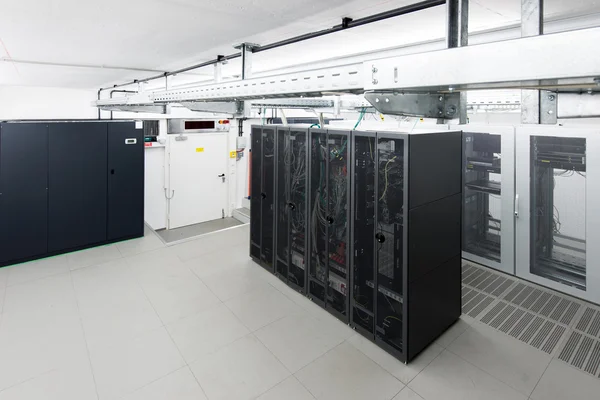 Small air conditioned server room with black racks and climate control unit — Stock Photo, Image