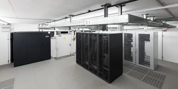 Weitwinkelblick auf kleinen, klimatisierten Computerraum mit Racks und Kabelkanälen — Stockfoto