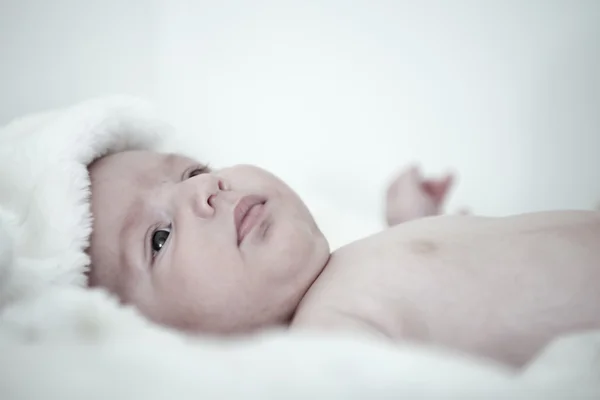 Bebê pensativo jaz de costas com a cabeça coberta com um cobertor — Fotografia de Stock
