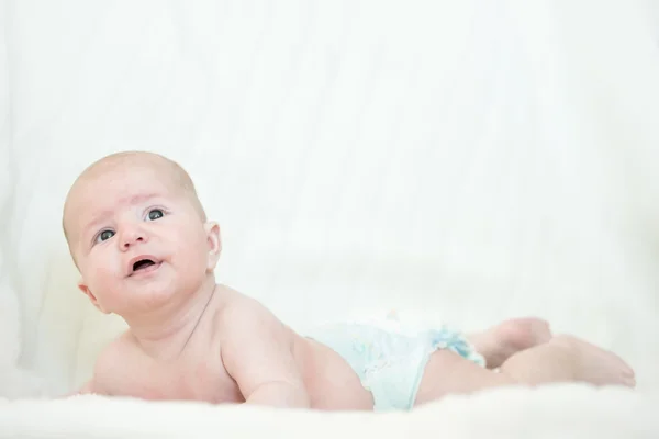Bebê recém-nascido olha para cima com a cabeça levantada uma boca aberta — Fotografia de Stock