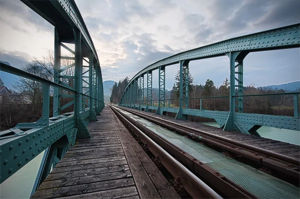 Railway train bridge with cyan painted steel framework over river — Stock Photo, Image