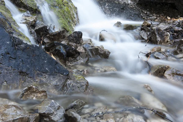 Studené alp voda tekoucí přes hrubé kameny na tyrolské hory — Stock fotografie