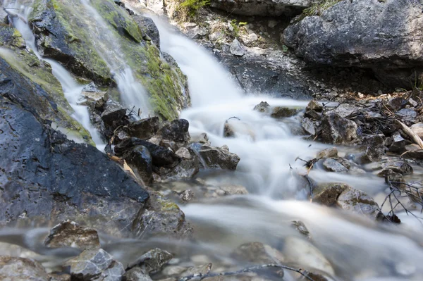 Studené alp voda tekoucí přes hrubé kameny na tyrolské hory — Stock fotografie