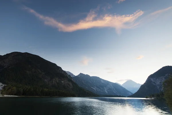 Idylického jezera plansee s hory a mraky smoothy při západu slunce — Stock fotografie
