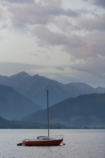 Velero único nada en el lago en medio de las montañas — Foto de Stock