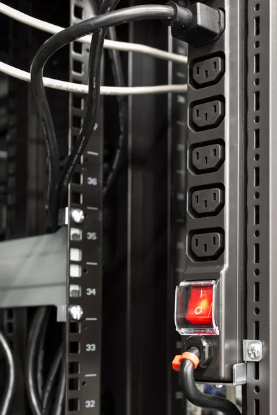 Barra di alimentazione nera in rack server con pulsante interruttore principale rosso — Foto Stock