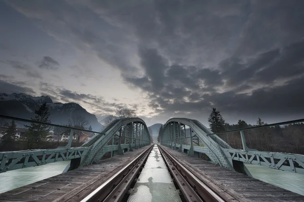 Ponte de trem mística feita de aço e céu dramático ao pôr do sol — Fotografia de Stock