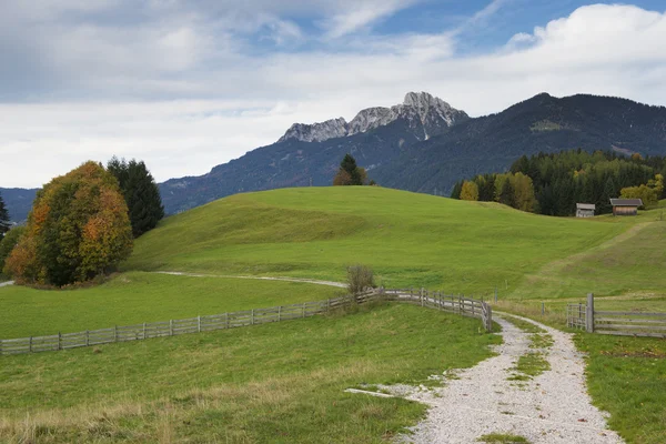 Paisaje idílico en austria en otoño con prado, montañas y carretera —  Fotos de Stock
