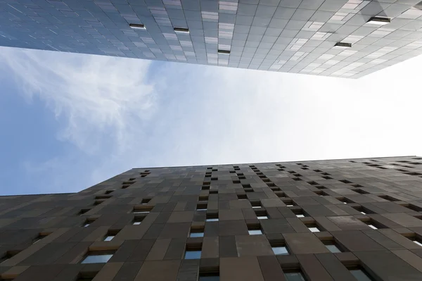 Perspectiva de baixo ângulo olhando para cima entre as paredes exteriores de dois arranha-céus modernos para o céu e nuvens acima — Fotografia de Stock