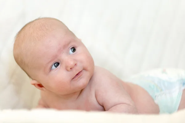 Interested small baby lifts up his head to look what's happen — Stock Photo, Image