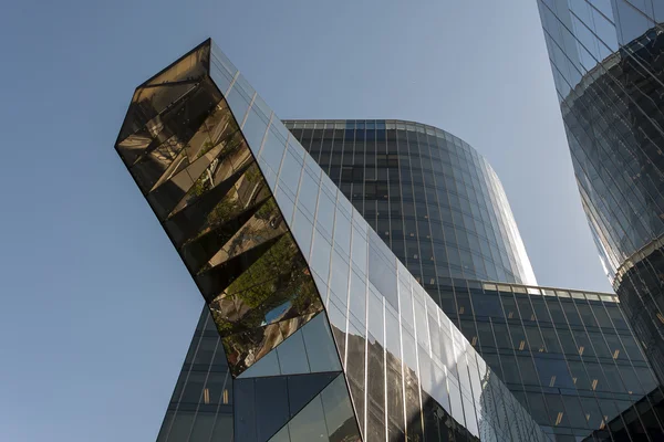 Prospettiva a basso angolo guardando in alto tra due moderni grattacieli commerciali al cielo blu nuvoloso — Foto Stock