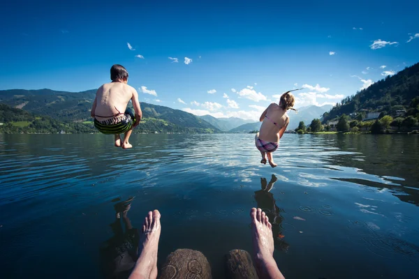 子供に飛び込むブルー湖で夏の日 ストックフォト