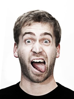 Young blonde man makes grimace with mouth wide open and tongue outside