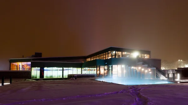 Edifício moderno com cores leves diferenciadas de uma piscina à noite em um dia de inverno — Fotografia de Stock