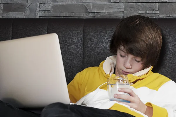 Young men fall asleep in front of his notebook while learning and drinkin a glass of water — Stock Photo, Image