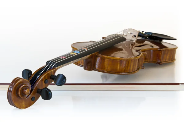 Klassische Geige aus Holz auf dem Stock liegend mit weißem Hintergrund — Stockfoto