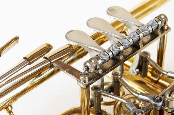 Silver guld trumpet ventiler i detaljvyn med vit bakgrund — Stockfoto