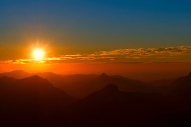 Sunset arada dağlar ve bulutlar gökyüzü ile